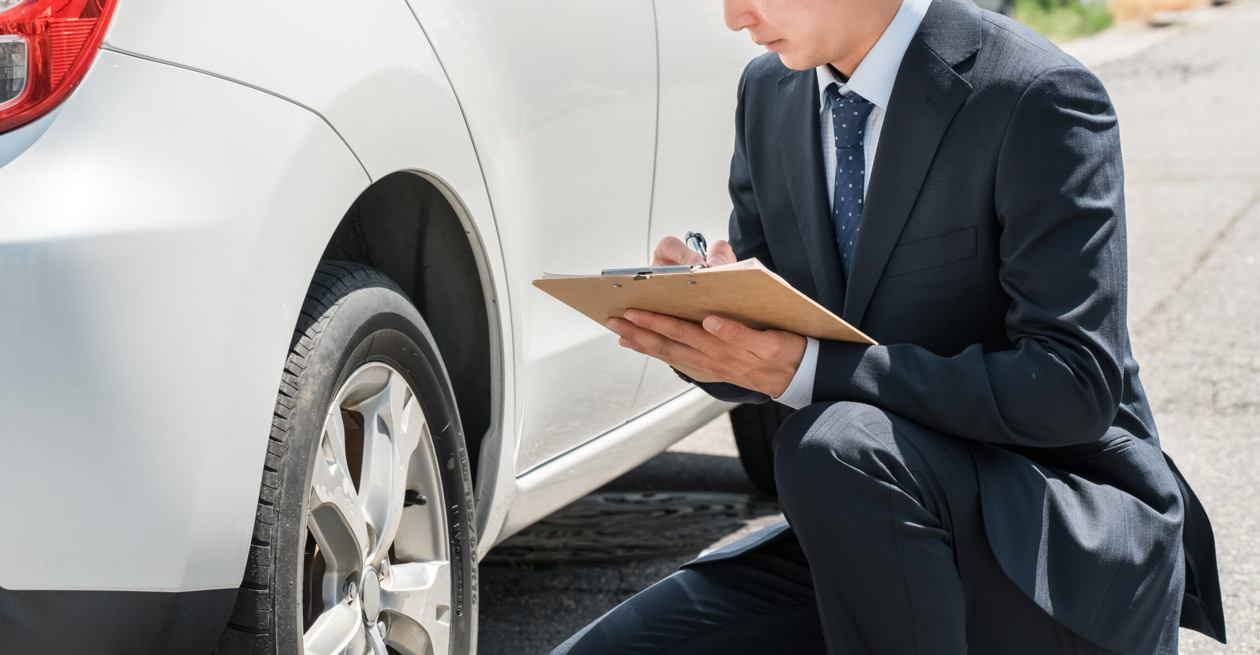 車両を確認して記録する男性
